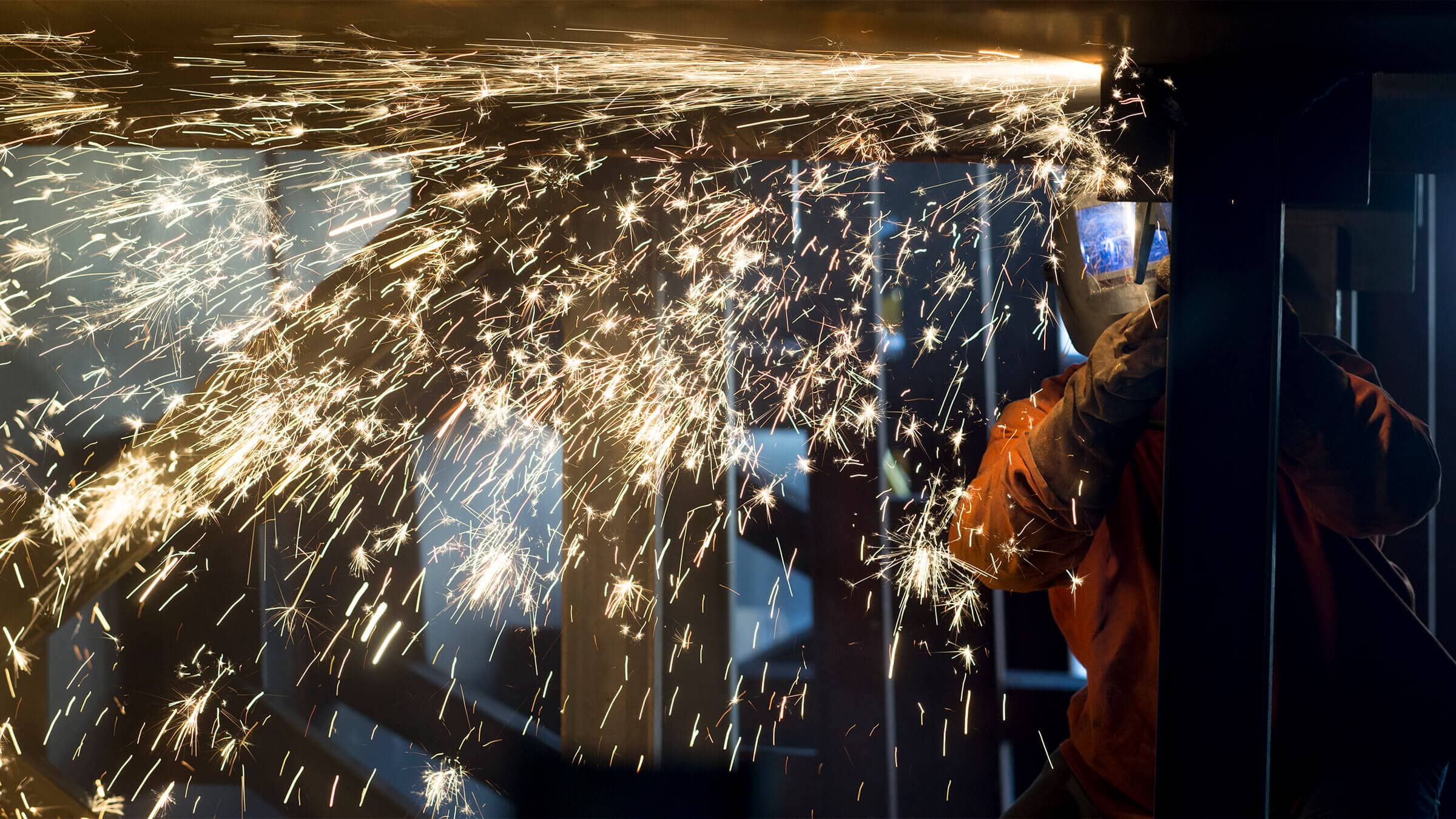 Welder at work with sparks coming off weld site