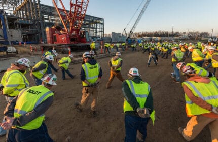 Construction workers stretching for safety in morning at jobsite