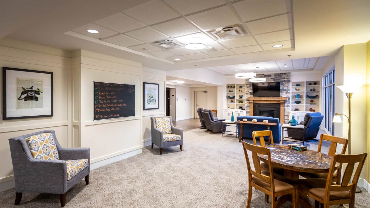 Spanish Cove Retirement Community Seating with Fireplace and Day Room Area, Artwork and Chalkboard on Wall